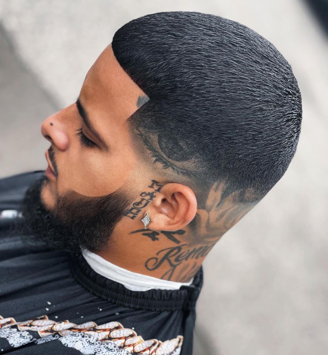 Straight across medium high fade with head tattoos